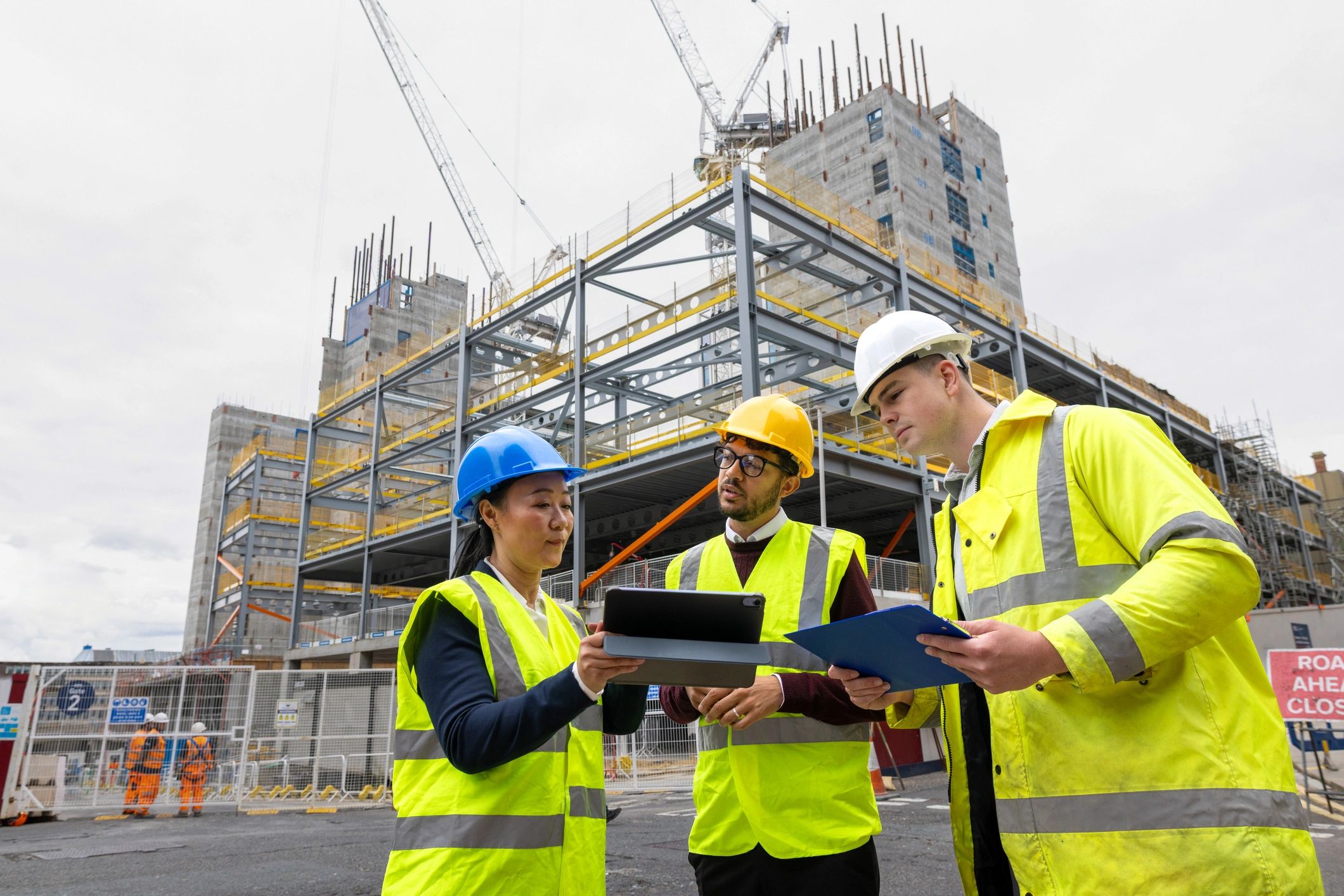 Construction and engineering professionals reviewing plans outdoors